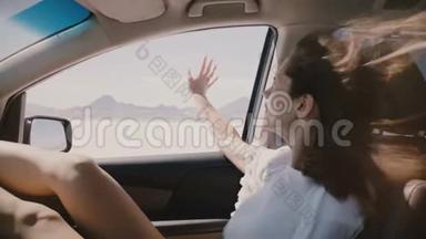特写POV拍摄的快乐女人与飞毛在一辆车上移动太快沿盐湖沙漠，伸出窗外。